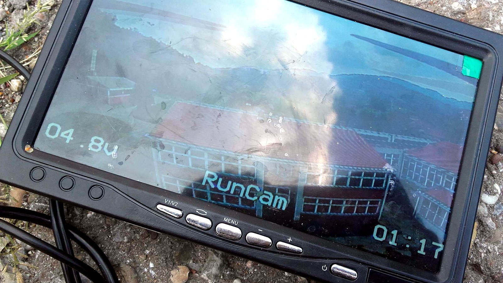 FPV monitor showing the quadcopter camera feed with battery voltage and flight timer overlay.
